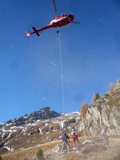 Der Helikopter bringt eine Ladung Zement